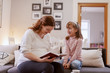 © Dusan Petkovic - Beautiful happy pregnant mother reading to her lovely daughter fairytale. Living room interior.