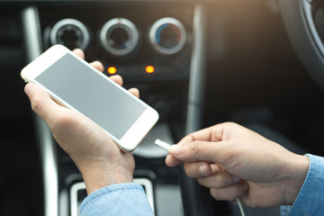 Male businessmen are charging mobile phones in cars. Mobile phone concept