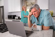 © elnariz - Older senior married couple in distress, concerned over mortgage, finances, financial earnings, debt