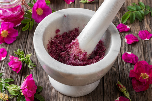 Fototapeta na drzwi i meble Płatki Rosa rugosa zmiażdżone cukrem w moździerzu