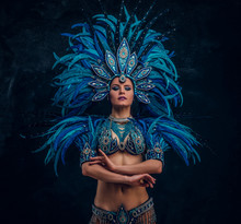 Beautiful Dancer Is Standing Crosses Her Hands. She Is Wearing Blue Feather Costume.