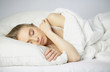 © Nataly Reinch - Sleep. Beautiful young woman sleeping in bed in the morning. Portrait of an attractive girl resting in a comfortable bed with a pillow and white bedding. Bedroom. Copy space for your text