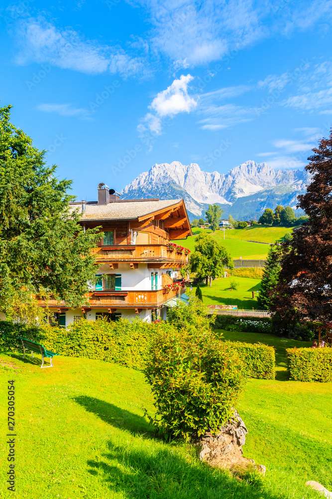 Traditional alpine house in village of Going am Wilden Kaiser with Alps ...
