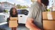 © Joshua Resnick - interracial couple moving into new home and taking boxes out of truck