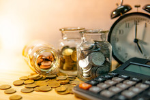 Calculator With Coin In Currency Glass Jar And Clock On Wooden Table. Compound Interest Rate Calculation. Financial Business Plan. Time Investment Concept