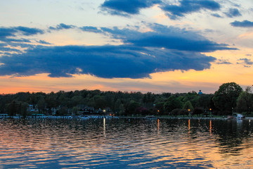 Blue clouds at dusk over Lake Geneva with lights in the distance.