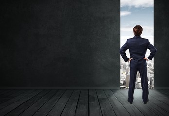 Young business man in black suit going out empty room