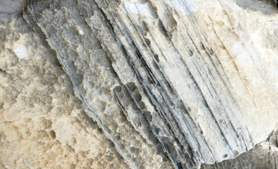 Texture of natural stone. Modern background. Image. Design for poster. Abstract backdrop. Black, grey, biege, sepia. Hole on the surface. Patterns and textures of rocks in nature. Closeup detail stone