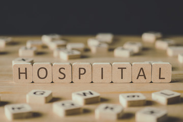 selective focus of cubes with word hospital surrounded by blocks with letters on wooden surface isol