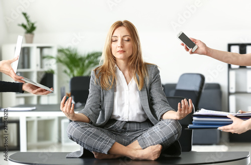 Mature businesswoman with a lot of work meditating in office Poster Mural XXL