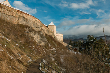 Medieval stone wall look from the outside. Road to the castle entrance