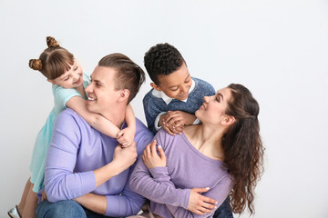 Wall Mural - Happy couple with little adopted children on white background