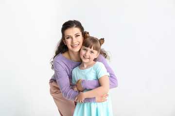 Wall Mural - Happy mother with little adopted girl on white background