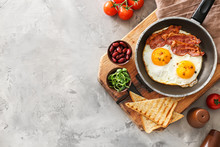 Traditional English Breakfast With Fried Eggs, Bacon, Beans And Toasts On Table