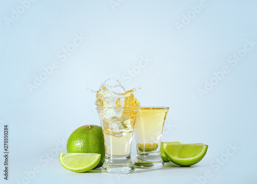 Fotomural Shots of tequila with splashes on light background