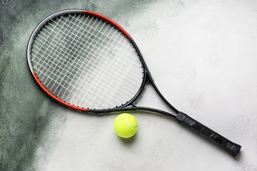 Tennis racket and ball on color background