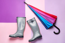 Stylish Umbrella And Gumboots On Color Background