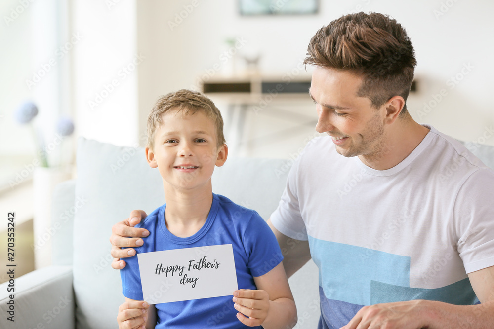 Little boy greeting his dad with Father's Day at home