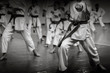 Kids training on karate-do. Banner with space for text. For web pages or advertising printing. Black and white photo without faces.