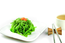 Hiyashi Wakame Chuka Or Seaweed Salad In White Bowl With Stainless Steel Chopsticks And Teacup On White Background, Japanese Food