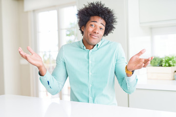 Canvas Print - African American business man wearing elegant shirt clueless and confused expression with arms and hands raised. Doubt concept.