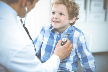 Wall Mural - Doctor and patient child. Physician examining little boy. Regular medical visit in clinic. Medicine and health care concept