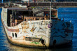 14.05.2019. Berlin, Germany. The view of the river of the city, and on it costs the old ship from metal with graffiti and drawings. The rusty boat in the middle of the city.
