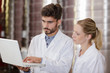© auremar - wine experts in white coats checking wine in laptop