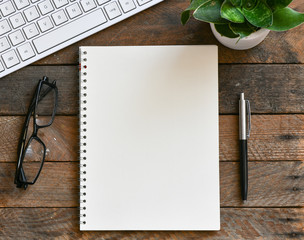 top view of blank notebook and pencil on wooden tabletop
