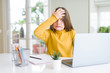 © Krakenimages.com - Beautiful young girl studying for school using computer laptop stressed with hand on head, shocked with shame and surprise face, angry and frustrated. Fear and upset for mistake.