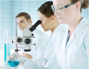 Wall Mural - Young Female Scientist Working with Microscope