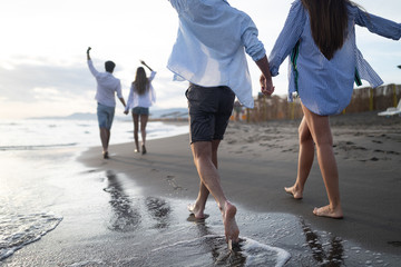 Happy cheerful couple having fun on a tropical beach at sunset