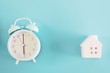 © ic36006 - Alarm clock and house model on blue background