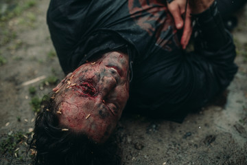 A young man in the image of a murdered medieval knight lying on the ground.