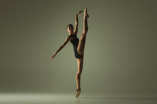 Graceful Ballet Dancer Or Classic Ballerina Dancing Isolated On Grey Studio Background. Showing Flexibility And Grace. The Dance, Artist, Contemporary, Movement, Action And Motion Concept.