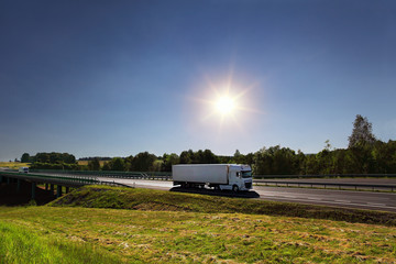 White truck transport on the road at sunset and cargo 