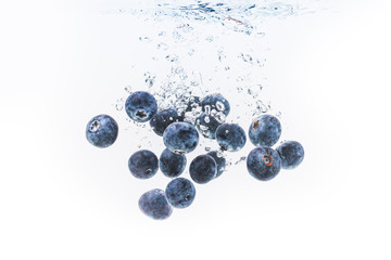 Wall Mural - Organic Blueberries dropped into clear water.