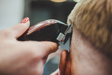 Canvas Print - beautiful girl hairdresser cuts a bearded man in the salon