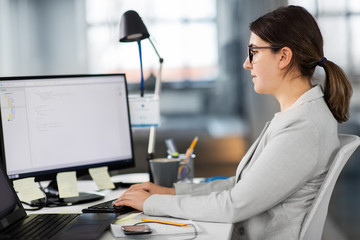 business, technology and people concept - businesswoman with computer working at office