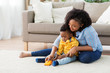 © Syda Productions - childhood, kids and people concept - happy african american mother and her baby son playing with toy car together on sofa at home