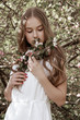 © Iveta - Beautiful young woman stay in apple blossom garden and keep a flowers bouquet u=in hers hands