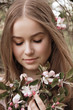 © Iveta - Beautiful young woman stay in apple blossom garden and keep a flowers bouquet u=in hers hands