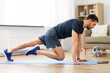 © Syda Productions - sport, fitness and healthy lifestyle concept - man with tablet computer doing running plank exercise at home