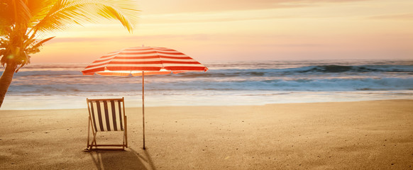 Wall Mural - Tropical beach in sunset with beach chair and umbrella