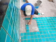 Tiled pool. The man hand while using spacer for installing tiles. construction work.Construction Pool.