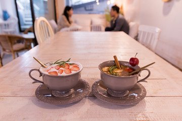 fruit flavored tea on the wooden table with blurred couple