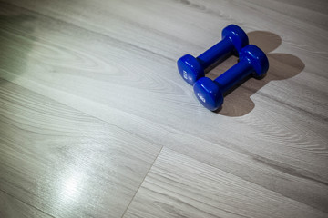 Blue dumbbells on the floor of 1 kilogram