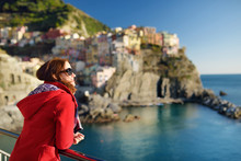 Young Female Tourist Enjoying The View Of Manarola, One Of The Five Centuries-old Villages Of Cinque Terre, Located On Rugged Northwest Coast Of Italian Riviera, Italy.