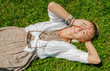 © Dmytro Flisak - Beautiful boho style woman with a lot of accessories is lying on green grass. Happy mometn