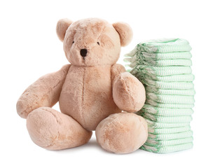 Wall Mural - stack of diapers and teddy bear on white background. baby accessories